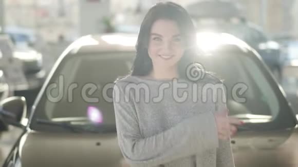 一幅美丽的黑种人白种人的肖像绿眼睛站在汽车经销商的阳光下眨着眼睛视频的预览图