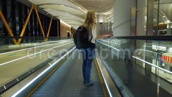 国际机场自动扶梯上的女人视频的预览图