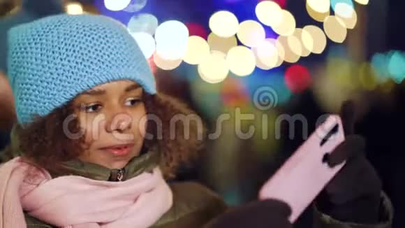 快乐的黑人女孩在圣诞节市场上为自拍视频做滑稽的脸视频的预览图