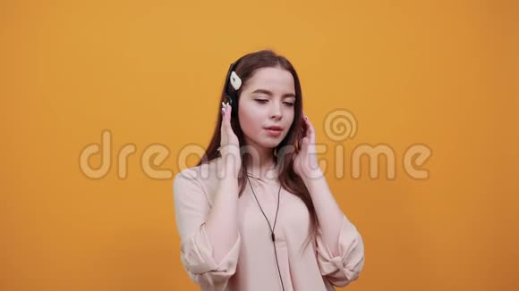 白种人黑发女人戴着耳机用手捂住嘴无聊视频的预览图