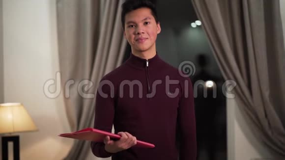 自信的亚洲男孩站在文件夹里看着相机微笑着的肖像快乐的大学生视频的预览图