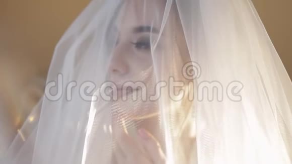 面纱下美丽可爱的新娘的脸婚礼视频的预览图