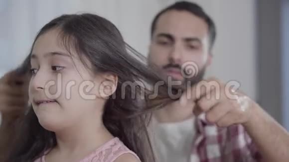 特写可爱的中东女孩等待父亲辫子尴尬的男人做发型视频的预览图