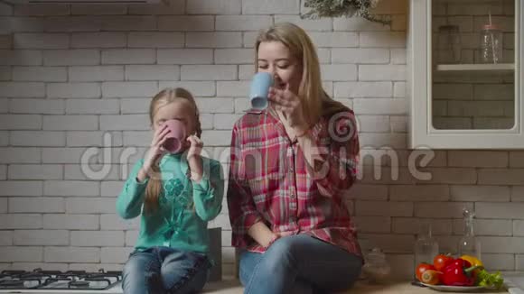 有热饮的家庭坐在厨房台面上视频的预览图