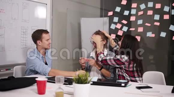 积极的年轻人在头脑风暴中一起欢笑坐在背后的白色办公桌前视频的预览图