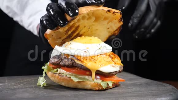 男厨师手按多汁汉堡缓慢滴酱和蛋黄带鸡蛋和新鲜的美国汉堡视频的预览图