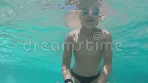 戴着泳镜的黑发男孩正在水下潜水和游泳视频的预览图
