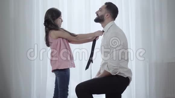 中东小女孩在室内系幸福父亲领带的侧景可爱的黑发女儿视频的预览图