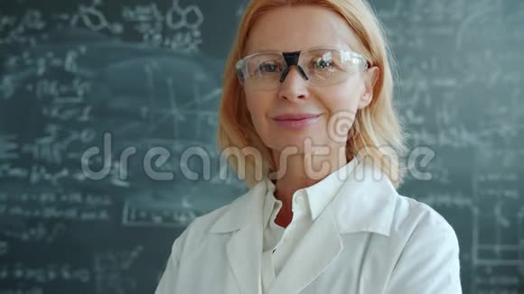 穿着白色长袍和室内护目镜的迷人女性医学研究员肖像视频的预览图