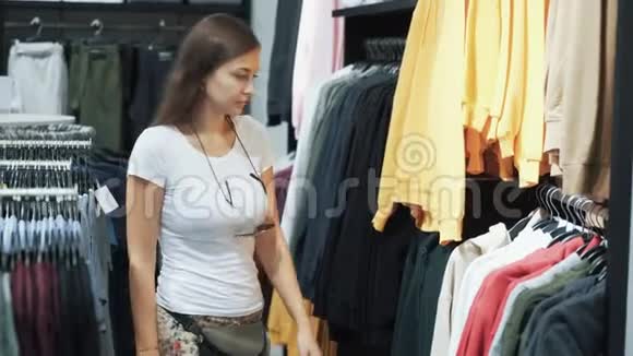 年轻女性在商店购物选择休闲服装试穿一下视频的预览图