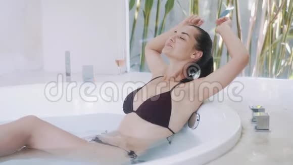 穿比基尼的女人在家里的大浴缸里休息视频的预览图