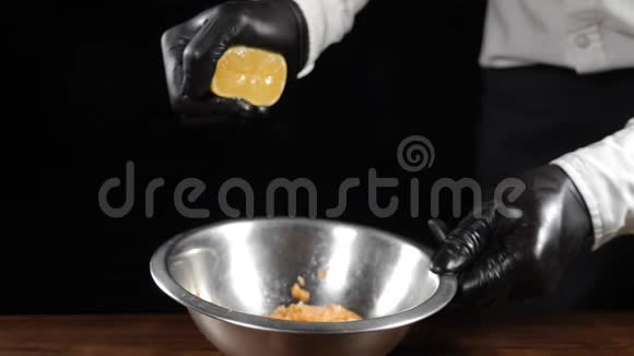 在黑色背景下拍摄的慢镜头令人惊叹的食物镜头用新鲜沙拉把柠檬汁挤到盘子里男性视频的预览图