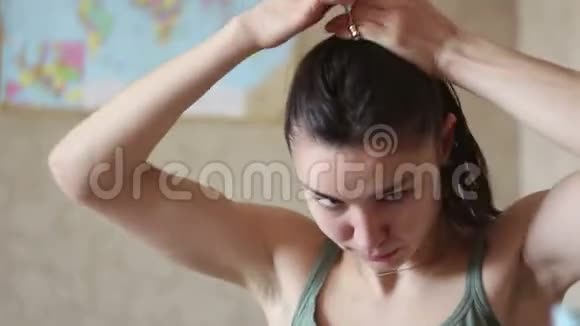 年轻有魅力的女孩坐在家里梳头视频的预览图