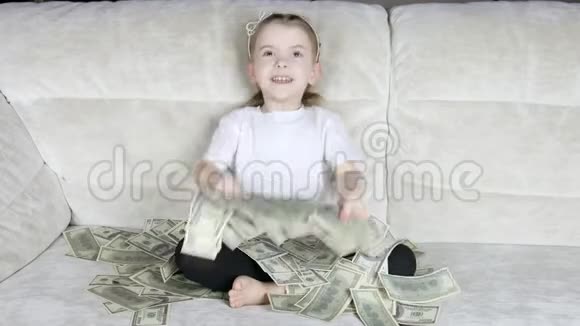 一个小女孩在沙发上扔了很多钱视频的预览图
