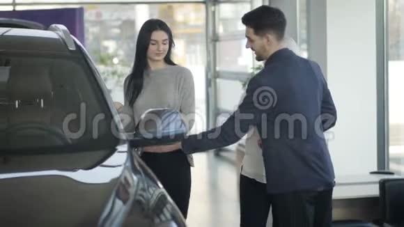 年轻自信的褐发白种人女商人在经销商店为成熟的母亲买新车成功女性视频的预览图
