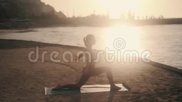 清晨在阳光下做伸展运动的女人剪影视频的预览图