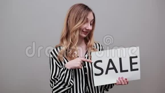 一位穿着条纹衬衫留着广告空白销售的曲线女人一边看一边视频的预览图