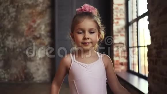 金发女郎头上戴着粉红色的蝴蝶结微笑着很漂亮的孩子慢动作在稳定器上射击视频的预览图