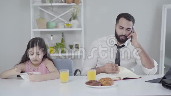 忙碌的中东商人在电话中交谈留下悲伤的女儿在盘子里混合谷物的肖像视频的预览图