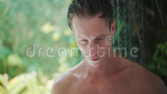 年轻人在绿色热带植物附近洗澡视频的预览图