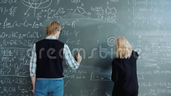 男人和女人一起写黑板上的公式视频的预览图