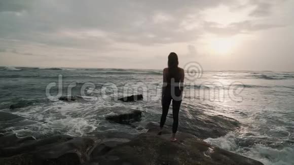 海洋海滩上的女孩剪影张开双臂背景是日落视频的预览图