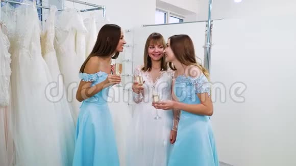 穿着婚纱的漂亮新娘和伴娘在沙龙中品尝葡萄酒视频的预览图