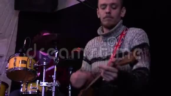 宾德在酒吧的音乐会音乐家演奏巴拉莱卡背景中一个鼓手视频的预览图
