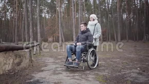 白种人妇女与坐轮椅的年轻残疾男子交谈的肖像病人的投标花费时间无效视频的预览图