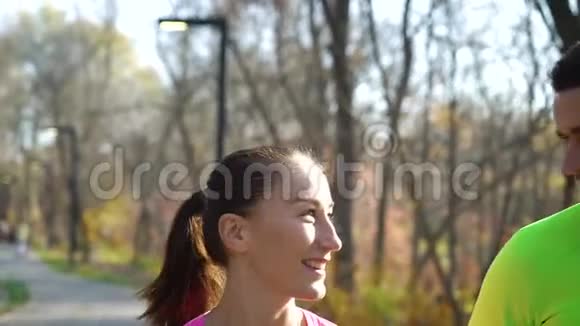 快乐的运动情侣在秋天公园慢跑视频的预览图