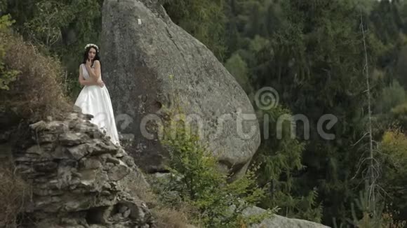 美丽可爱的新娘站在山上恋爱中的女人视频的预览图