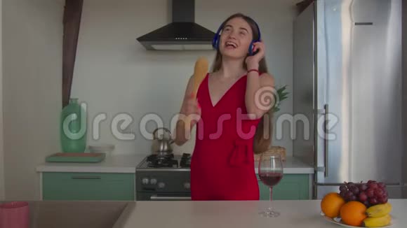欢乐的女人在厨房里唱着铲子视频的预览图