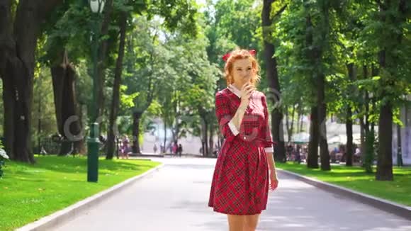 带着冰淇淋在公园散步的红发女孩视频的预览图