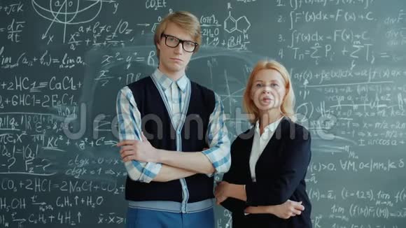 男人和女人站在黑板附近的肖像用公式看镜头视频的预览图