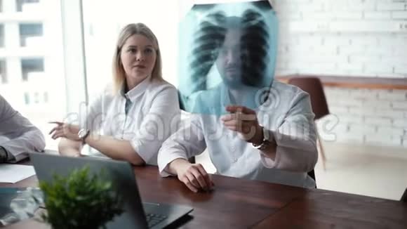 由三名成人和青年医生组成的医疗队讨论胸部X光视频的预览图