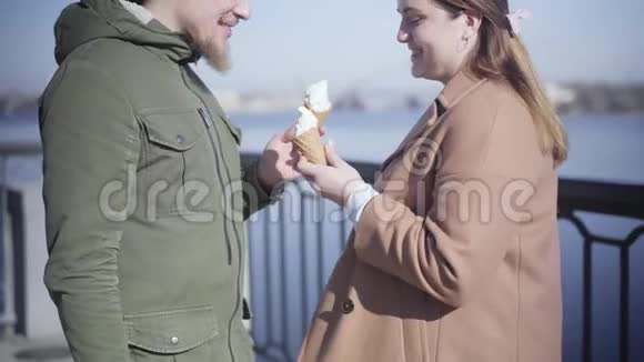 站在河岸上的白人胖乎乎的女孩和一个面目全非的留着胡子的男朋友谈话视频的预览图
