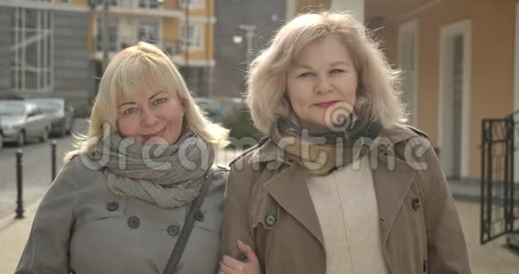 在城市街道上高白种人的高级女性看着镜头微笑快乐的中年退休人士视频的预览图