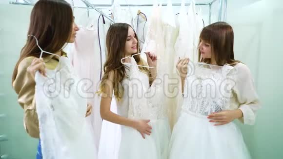 在婚礼沙龙里的漂亮女孩在试着穿衣服和说话视频的预览图