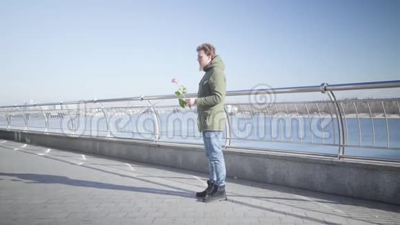 年轻的白种人胖乎乎的女孩跑到男朋友身边站在河岸上拥抱着他幸福的侧观视频的预览图