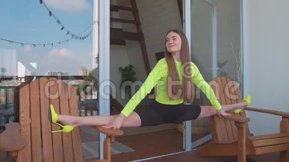 穿高跟鞋的女人在两把椅子之间劈叉视频的预览图
