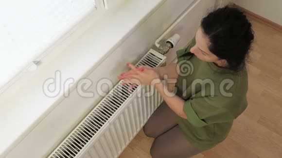 女人用暖气片暖手视频的预览图
