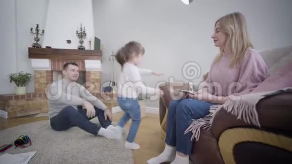快乐的白种人女孩的肖像向家里的父母展示她的舞蹈技巧年轻的一对夫妻视频的预览图