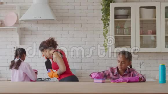 可爱的非洲女孩用洗涤剂清洗桌子视频的预览图