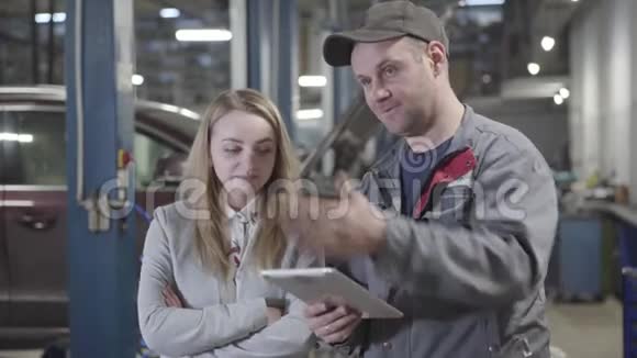 白种人成年男女在服务站讨论汽车修理的肖像成功的女商人视频的预览图