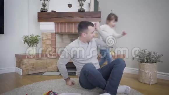 一个性格开朗的白种人女孩牵着他的手围着一个成年男人跑来跑去微笑的父亲带着他可爱的女儿视频的预览图