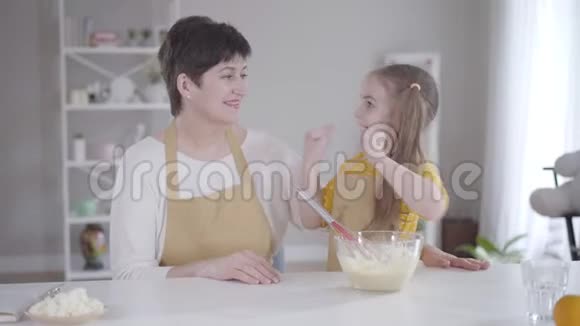 可爱的积极女孩给奶奶在厨房幸福的女人拥抱孙女高加索家庭视频的预览图