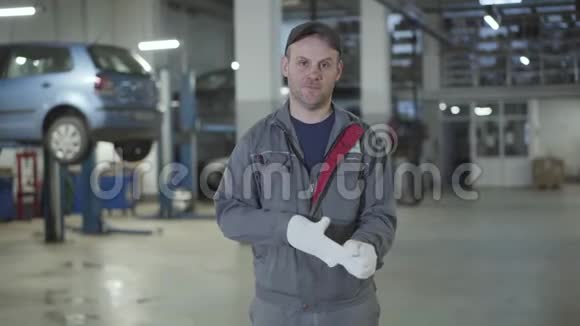 年轻自信的白人男子在汽车修理店摆姿势的肖像专业男性汽车修理工视频的预览图