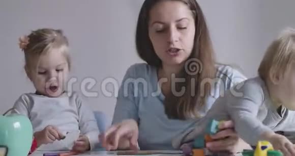 白人年轻母亲与两个女儿玩耍的特写镜头漂亮的金发女孩整天和视频的预览图