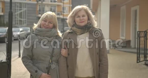 两位高加索高级妇女在户外摆姿势的肖像快乐成熟的退休人员微笑着站在镜头前视频的预览图