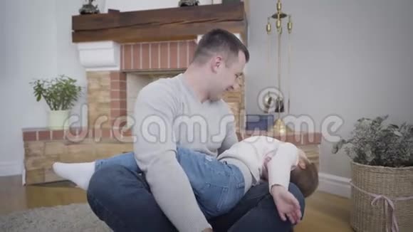 有趣的白人父亲和女儿在室内玩的肖像快乐的年轻人和小女孩坐在柔软的视频的预览图